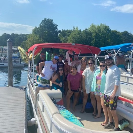 Group of people on a boat at a dock on a sunny day.